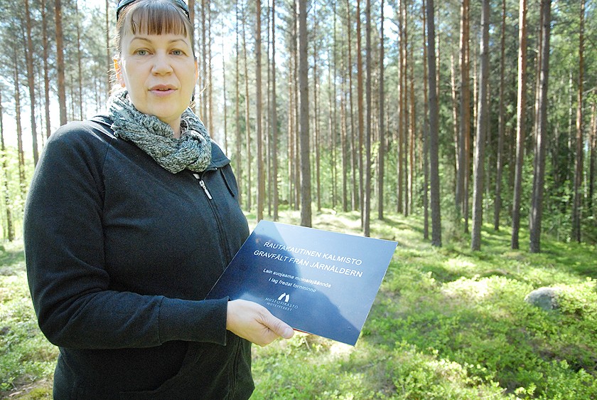 Satu Mikkonen-Hirvonen esittelee kiskolaisyrityksen tekemää uutta kylttiä, joilla jatkossa merkitään muinaiskohteet.