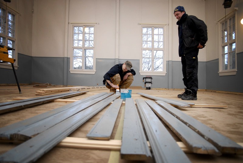 Vanhat jalkalistat kiertävät kohta uutta lattiaa. Sami Linsén maalaa listat, Kari Blomqvist kehuu väriä.