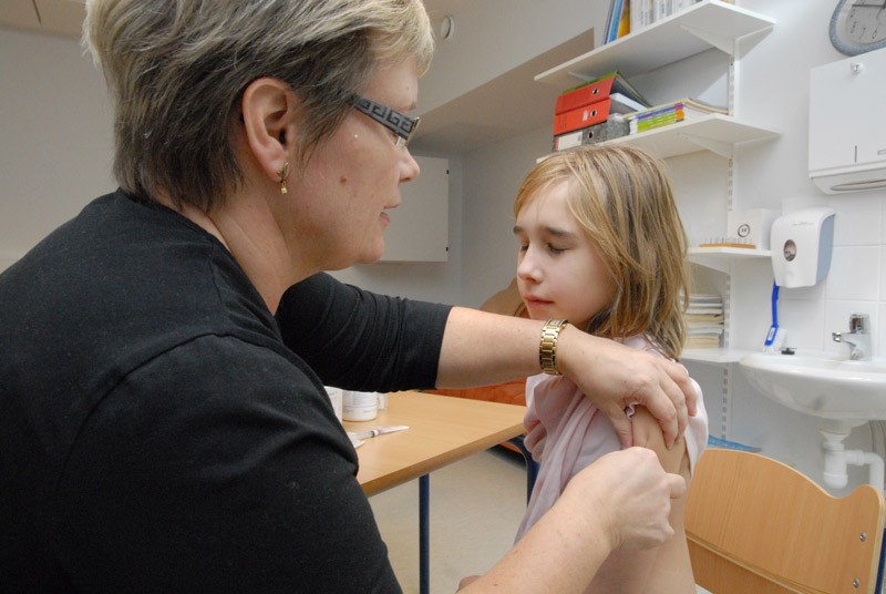 Aada Sipilä nipisti silmät kiinni, kun Kirsi Vasama tuikkasi sikainfluenssarokotuksen tämän käteen Särkisalon koulussa tiistaina.