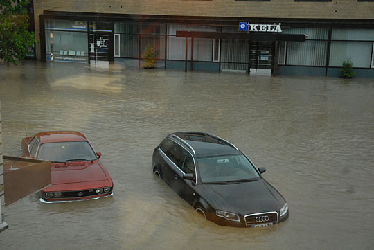 Pysäköityjä autoja jäi tulvan alle, ja palokunta yritti siirtää niiitä.