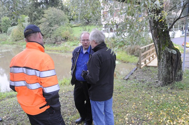 Henri Tiainen (vas) kuvaa Pesänlammesta jokeen menevän putken. Neuvonpidossa kaupungin Kari Raita ja Markku Pihakivi.