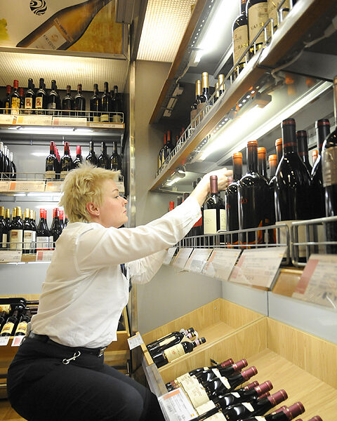 Tiina Salminen pistää pullot riviin Silja Europan myymälässä.