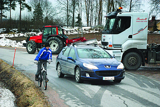 Kalle Paavola pyöräilee kouluun Sauruntien kapeaa piennarta pitkin. Liikennettä tiellä riittää aamusta iltaan.