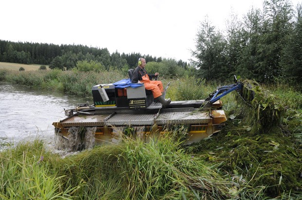 Ville Augustsonin ajama kone kömpii rannalle kuorman kanssa,