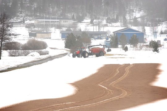 Teijon kentällä annetaan lumien sulamiselle vauhtia hiekoittamalla.