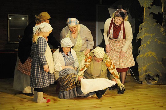 Näytelmää harjoiteltiin jo roolivaatteissa viime sunnuntaina. Etualalla Elina (Taina Degert) on lyönyt kirveellä jalkaansa, Mari (Ritva Blomqvist) antaa ensiapua.