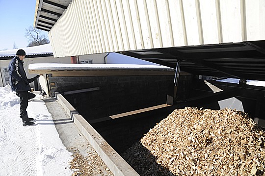 Juha Bäckmand näyttää, miten hakevaraston katto nousee kuin suuri kita.