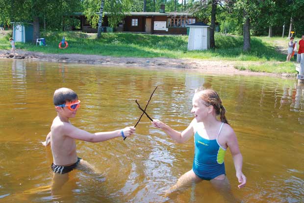 Lukas Lumme ja Nella Vuoriranta innostuivat miekkailemaan järvestä löytyneillä kepeillä.