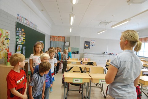 Opettaja Riikka Uusitalo ohjaa ekaluokkalaiset jonoon. Oppilaat kokoontuivat aulaan, jossa rehtori Hemmilä opasti koulun alkamisesta.
