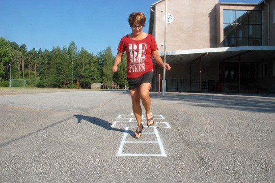 Toista vuotta rehtorina aloittava Sirkku Leikkonen tarkastaa juuri maalatut hyppyruudut.