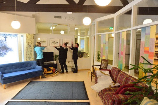 Taulut seinään ja valmista tuli: maalausten paikkaa Särkisalokodin seinään mallailevat Päivi Lindeman, Erja Alander ja Harriet Corin.