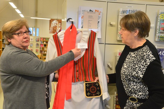 Arja Kämpe ja Ritva Männistö pistävät Viljakkalan pukua vaatepuulle.