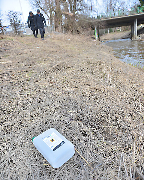 Kirkonkyläyhdistyksen Maija Poutanen ja Markku Koskinen Perniönjokivarressa. Joenpenkka on täynnä sekalaista roskaa.