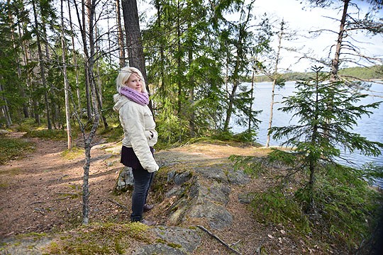Suvi Valkonen opastaa matkailijoita Teijon luontokeskuksessa tämän kesän ajan. Taustalla kimmeltää Matildanjärvi, jonne on istutettu juuri kirjolohta.
