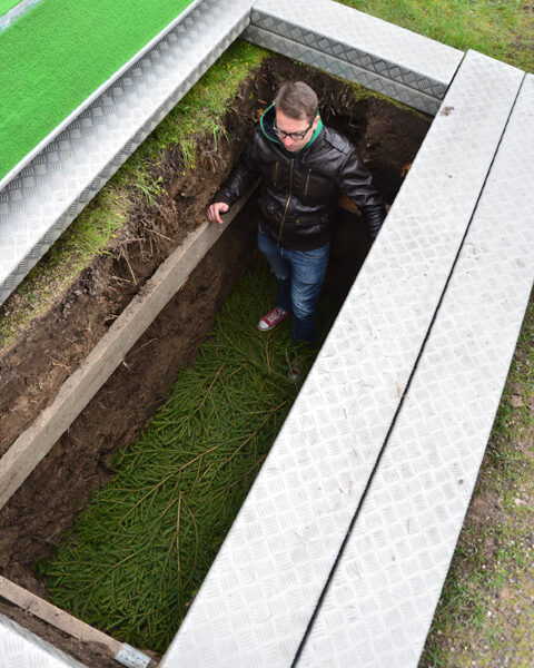 Aluekappalainen Johannes Alaranta näyttää, miten haudan pohja on havutettu. Vanha tapa on vielä Perniössä käytössä.