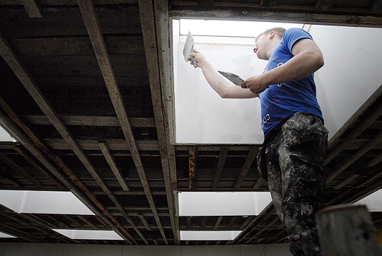 Kattoikkunoiden valokuilujen seinät maalataan samalla kuin katotkin. Sauli Virtanen veti pintoihin tasoitetta.