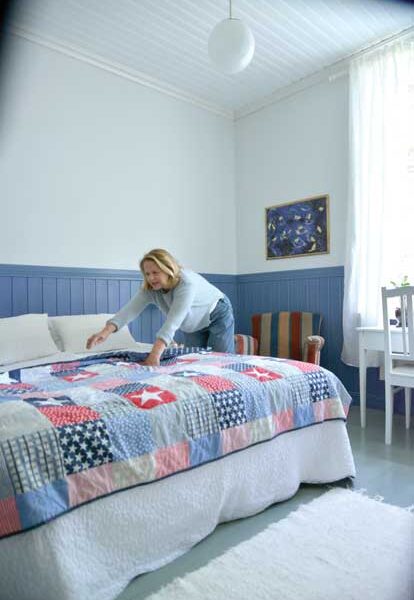 Tulevassa majatalossa on jo huone esittelykunnossa. Taina Kotilainen pistää vielä päiväpeiton suoraan.