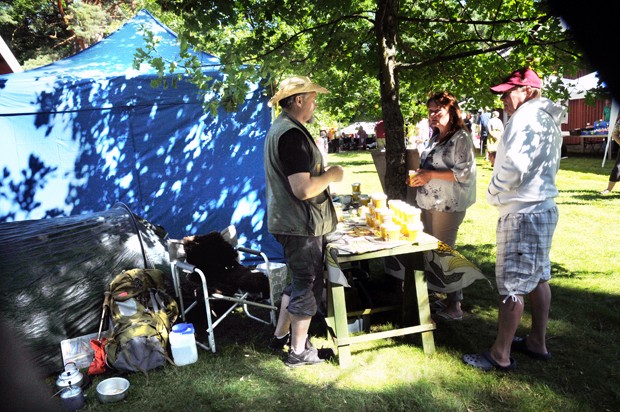 Eräopas Teijo Lehtola myi uuden sadon hunajaa Helsingistä saapuneille Taru Rantamäelle ja Jukka Karttilalle.