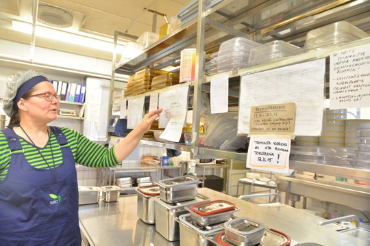 Alholan keittiössä tehdään ruokaa omaan taloon ja muuallekin; Tuula Mäkelä näyttää muistilappuja siitä, mitä kaikkea kokatessa ja pakatessa on muistettava.