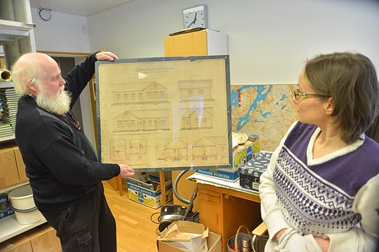 Vanha rakennuspiirros kelpaisi vaikka tauluksi seinälle. Paavo Heinonen ja Katja Pohtola ihailevat Sikstus Rönnbergin tussin jälkeä. Kuvassa on Tuohitun koulu.