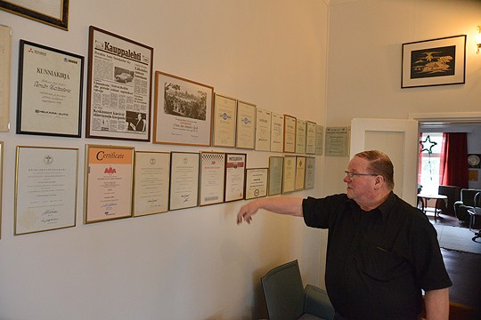 Jouko Smolanderin kotona tulevat vuodet vastaan; kunniakirjoja ja todistuksia autokaupan ja huoltoasema-alalta on seinän täydeltä.