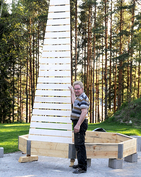 Eikka Kukkamaa näyttää seinäelementin avulla majakan mittasuhteita.