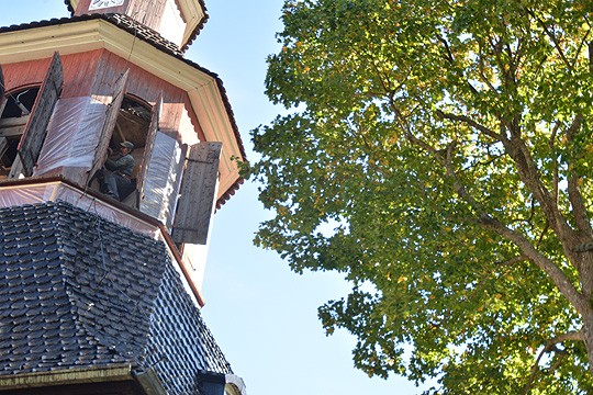 Tapulin katto kiiltää tuoreessa tervassa. Ennen ylempänä olevien paanujen ja luukkujen tervaamista Juha Förström ja Pertti Lammi suojasivat punaiset osat muovilla.