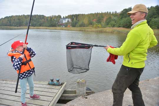 Merestä nousi laiturille muutama komea ahven. Ville Toivonen kaappasi Anette Lahtisen saaliin haavilla laiturille.