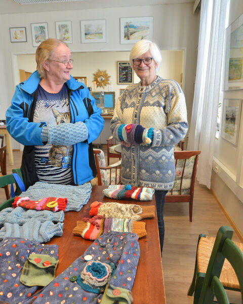Ritva Virta ja Marja Matikainen neuloivat muhveja vanhuksille. Tänään ne pääsevät käyttöön.