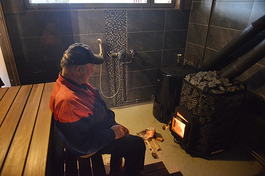 Homma käy: Kaarlo Saaristo tuikkasi tulet uuteen kiukaaseen viime torstaina. Tänään sauna lämpiää taas.