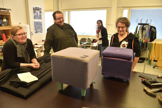 Tekstiilipajassa tehdään monenlaista, kuten nämä kaksi rahia. Marika Rannan (oik) kätten jälkiä tutkivat Saija Lempiäinen ja Otso Lapila ja taka-alalta työnsuunnittelija Sari Soininen.