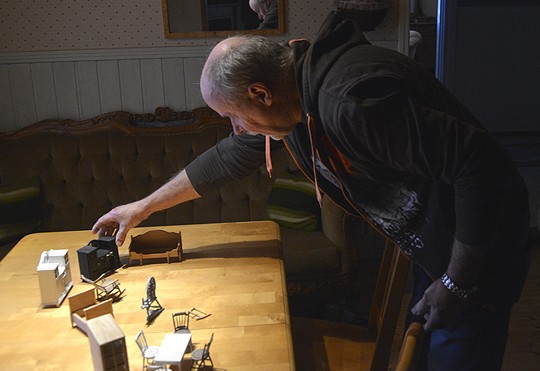 Christian Lundkvist asettelee pöydälle tekemiään huonekaluja.