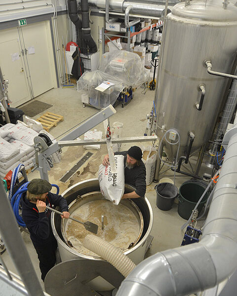 Kyläpanimossa aloiteltiin keskiviikkoaamuna Teijo-oluen keittoa. Tuomo Holm kaataa maltaita pataan ja Peter Torniaisella on sekoitusvuoro.