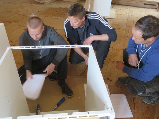 Tim Ja Ari Borgström sekä Janne Salminen selvittämässä keittiökalusteiden kokoamisohjeita.