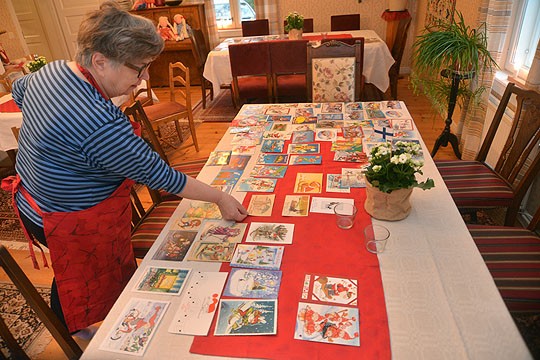 Leila Räsänen esittelee vuosikymmenien aikana kertyneitä joulukortteja, joissa joulupukki kulkee miten milloinkin.