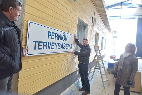 Kyltti paljastaa, mikä on tämä rakennus. Arto Koskela ja Ville Karjalainen sovittelevat jatoimitusjohtaja Kirsi Ruohonen sanoo, koska korkeus on oikea.