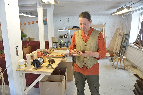 Rullasta tuleva metallilanka kiristää jouhet harjan puuosaan. Kaarnalaiva työllistää Kai Heiskarin lisäksi myös hänen vaimoaan ja tytärtään.