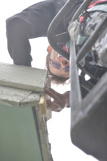 Kai Viirret kirjoittaa mittoja muistiin Ylikulman rukoushuoneen katon reunalla.