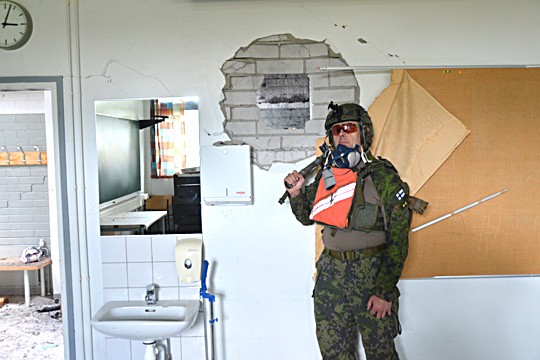 Perniön vanha lukio toimi eilen ja tänään Kaartin jääkärirykmentin ja poliisin yhteisharjoituksen kohteena. Yliluutnantti Juhopekka Koivusilta näyttää, miten seinästä on menty läpi.