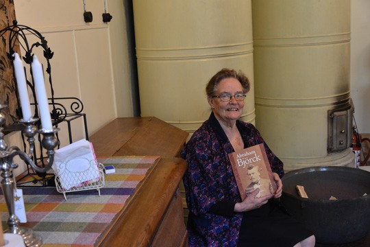 Yhdessä kuvassa on paljon koulumaailmaa: Leena-Maija Alho teki elämäntyönsä opettajana, samoin kirjan kannessa komeileva Abraham Björck. Takana hohkaavat Kuivaston vanhan koulun uunit.