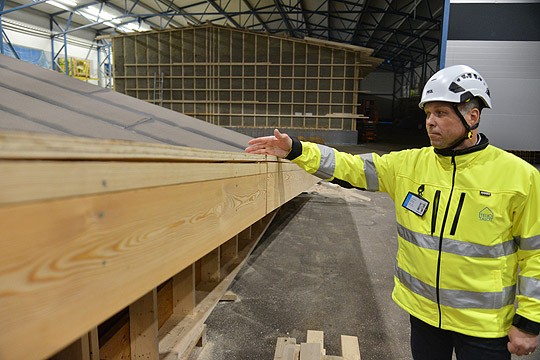 Ismo Laitakari näyttää, mistä kattorakenne katkeaa kuljetusta varten.