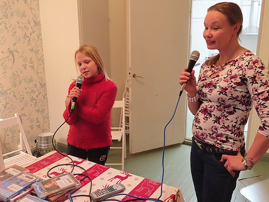 Henni Moilanen (vas) ja Sari Kyllönen aloittivat illan laulamalla karaokessa lastenlauluja.