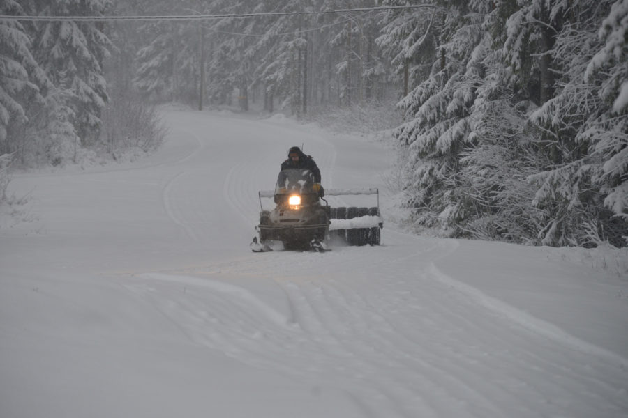 Mies ajaa latukonetta.