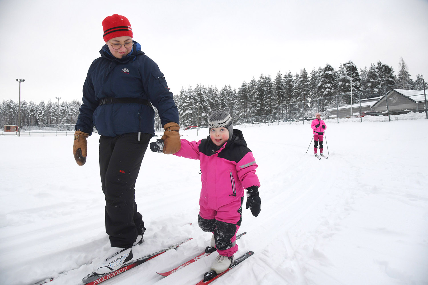 Iida Varemäki opettaa 2-vuotiasta Neela Saarta hiihtämään Melassuolla.