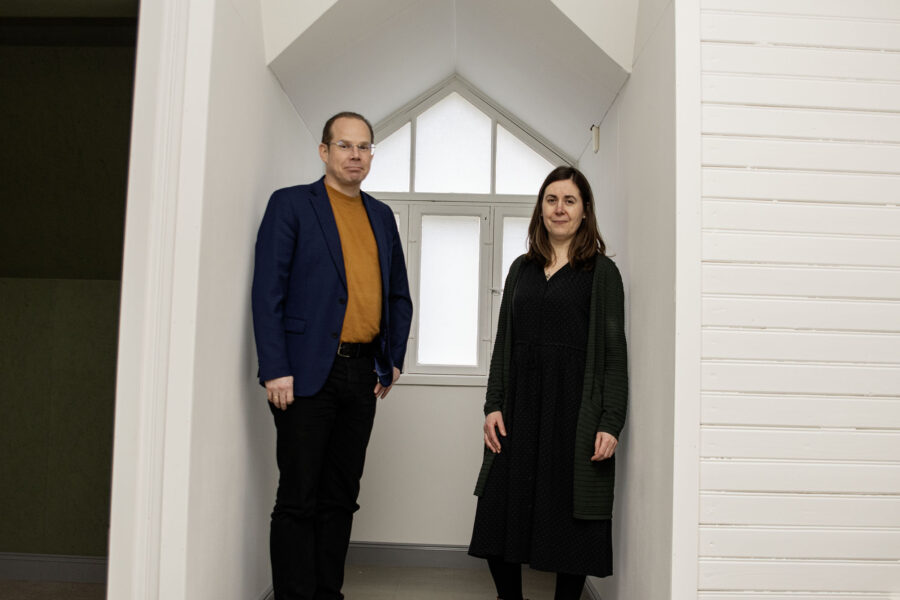 Mies ja nainen seisovat syvennyksessä ja katsovat kameraan.