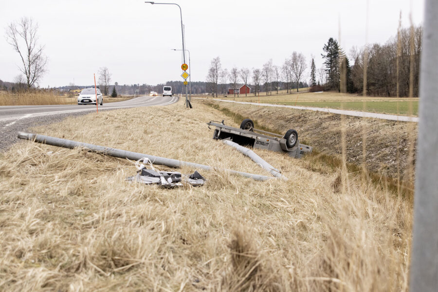 Tien vieressä makaa kaatunut valotolppa ja peräkärry.