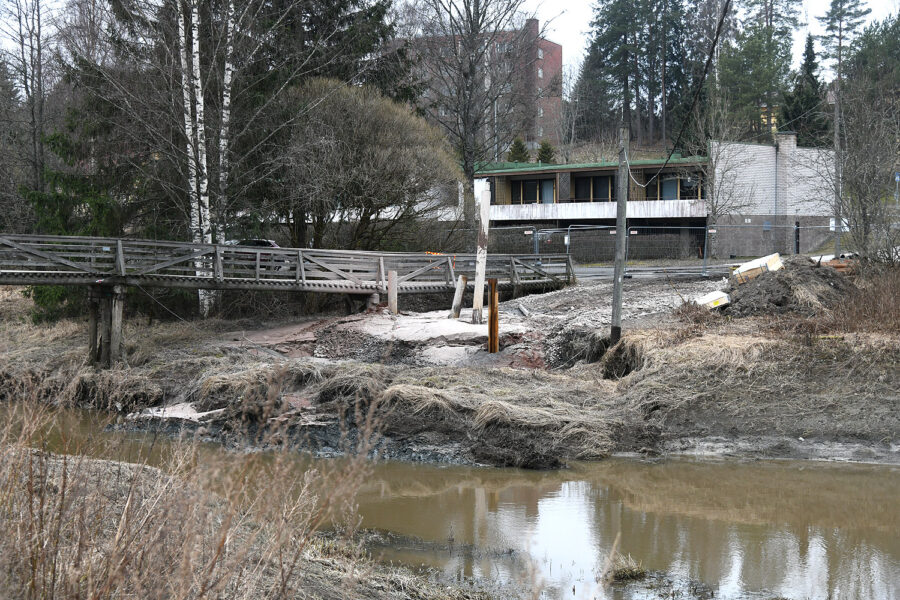 Kuvassa näkyy pysähtynyt rakennustyömaa ja vajonnut jokitörmä.