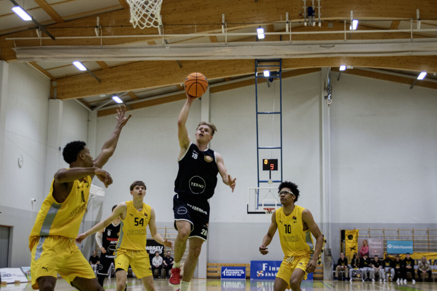 Rantapaju heittää palloa puolustajien yli yhdellä kädellä.