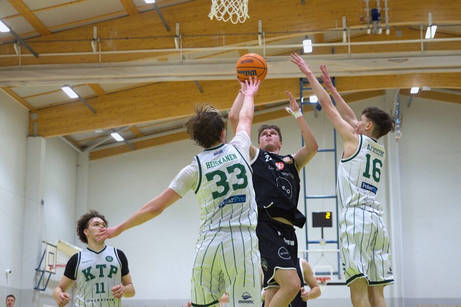 Tino Yli-Junnila yrittää nostaa palloa puolustajien edestä koriin.