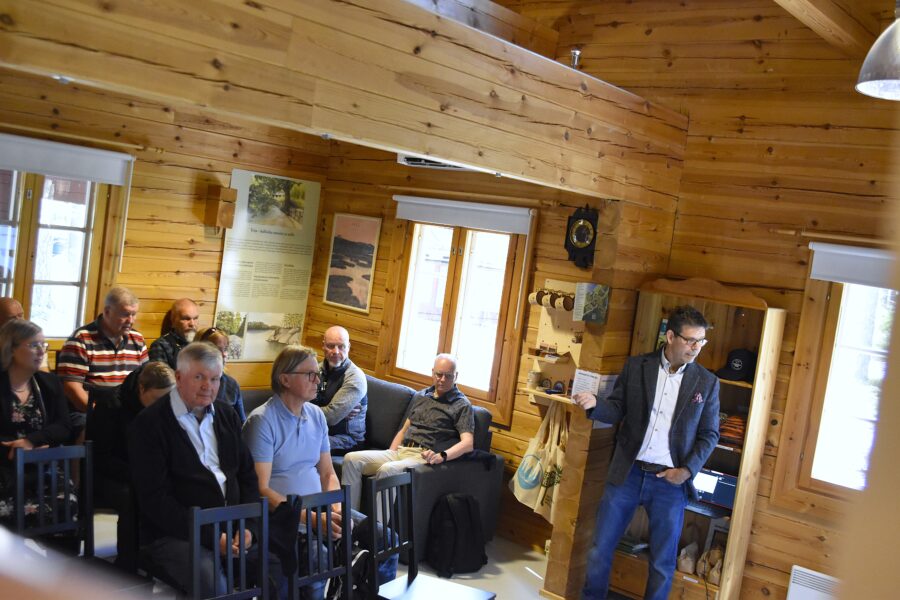 Mies puhuu yleisön edessä.